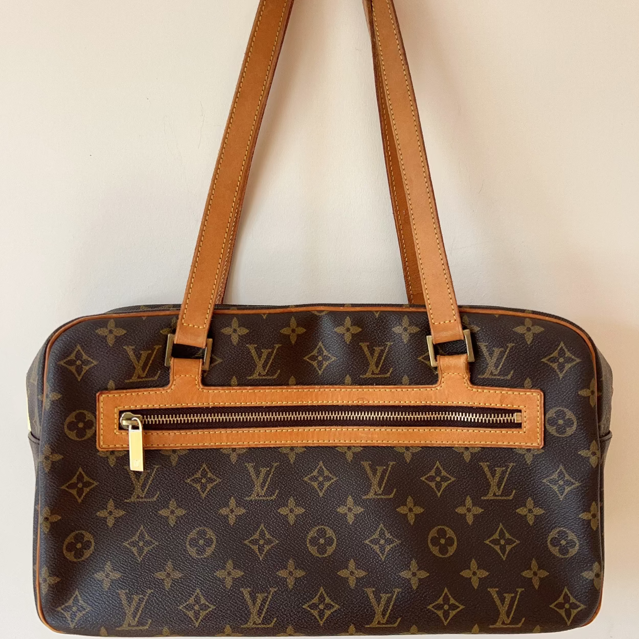 Designer handbag with monogram pattern on a plain background