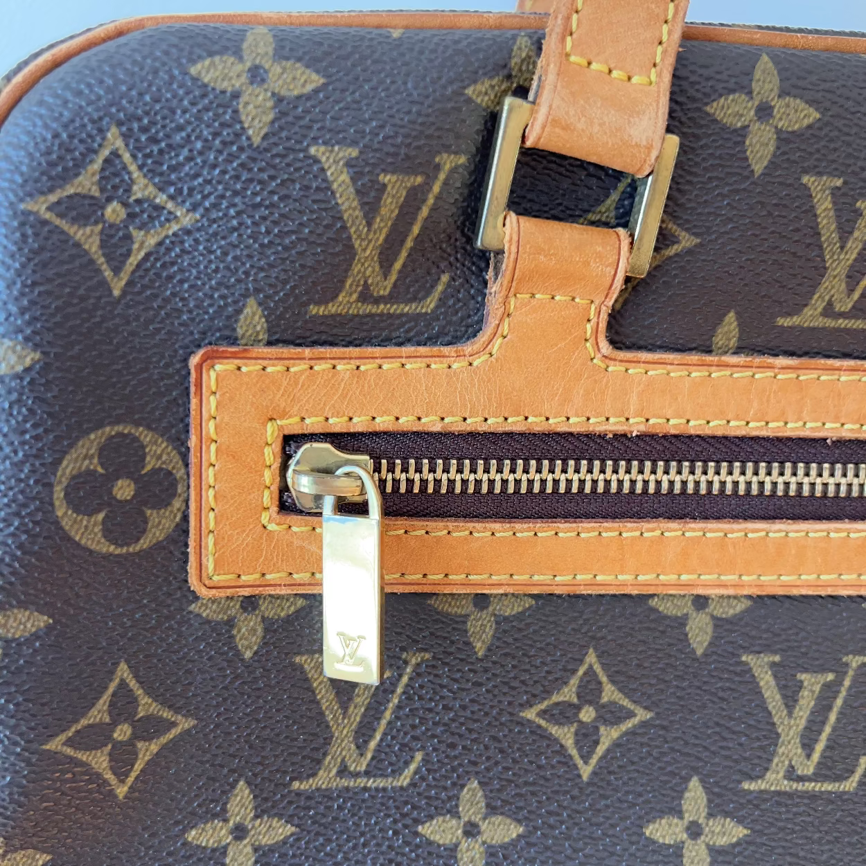 Close-up of a Louis Vuitton handbag with monogram pattern and visible brand logo.