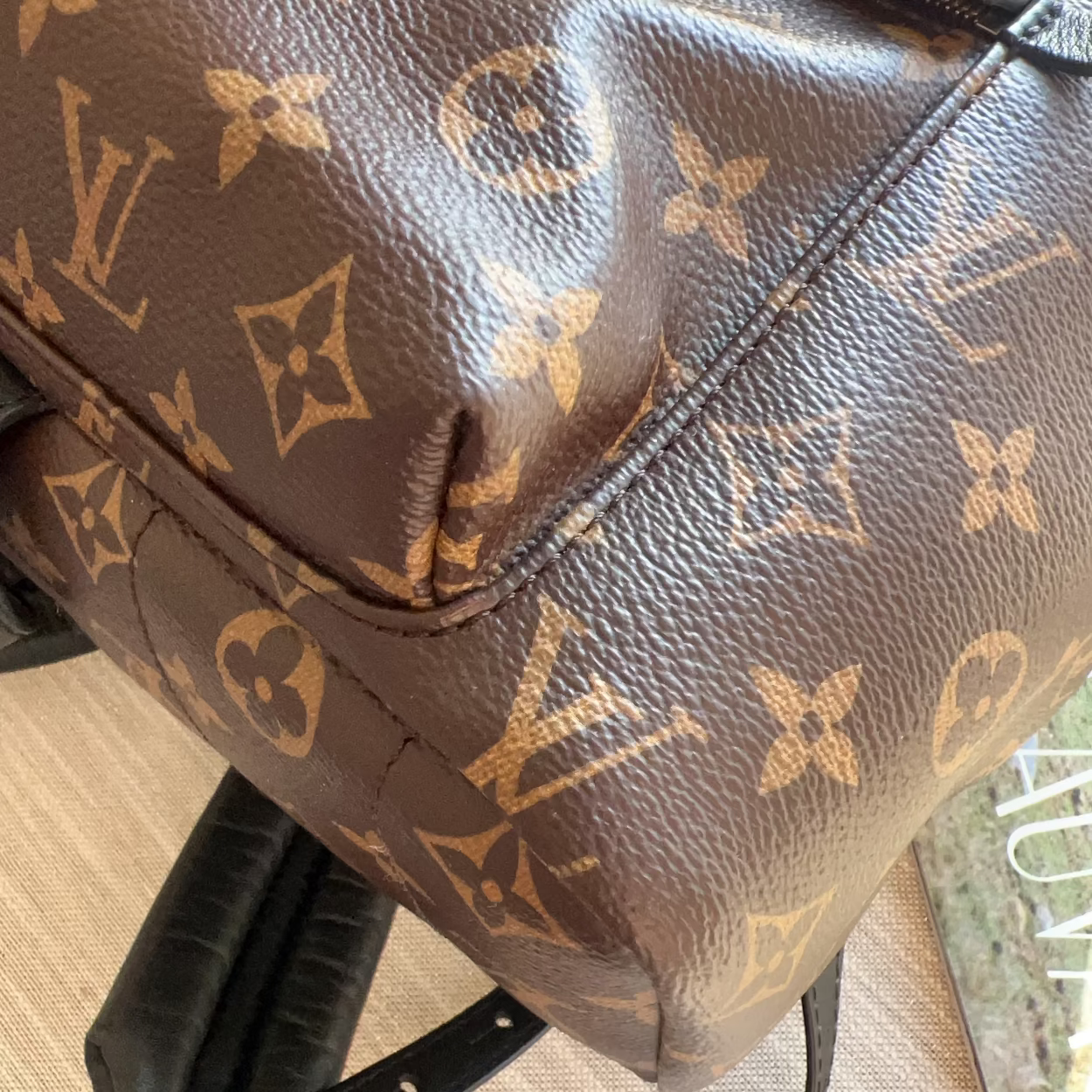 Brown leather bag with monogram pattern on a chair