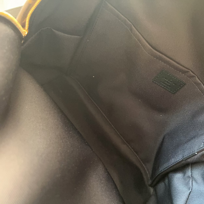 Close-up of a black fabric patch on a gray garment with a visible brand logo.