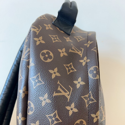 Brown backpack with monogram pattern on a light background