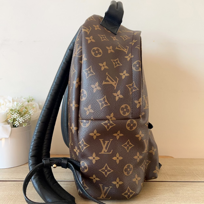 Brown backpack with monogram pattern on a wooden surface