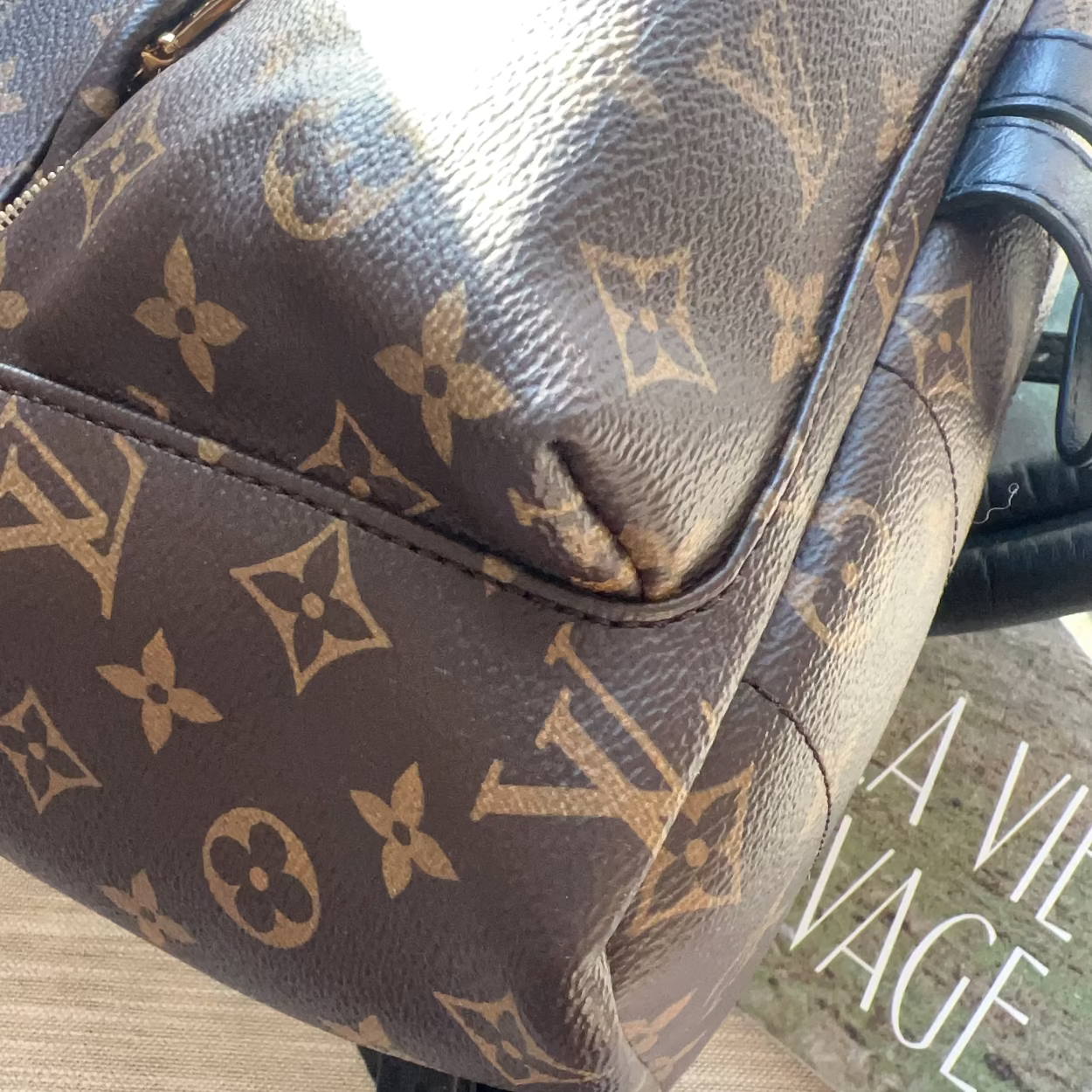 Brown leather bag with visible brand logo on a textured surface