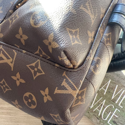 Brown leather bag with visible brand logo on a textured surface