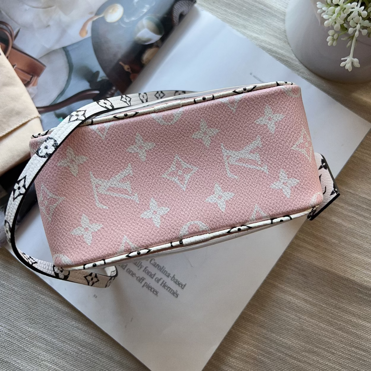 Pink handbag with monogram pattern on a magazine