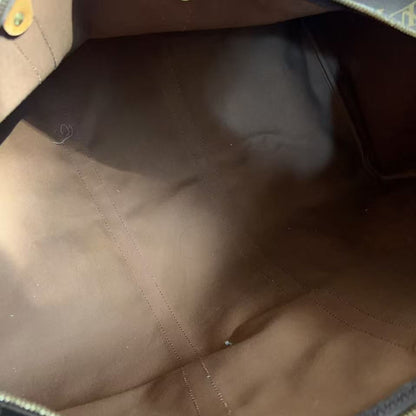 Close-up view of the interior of a Louis Vuitton bag, showing the brown fabric lining, gold-tone hardware, and a portion of the classic monogram canvas at the top.
