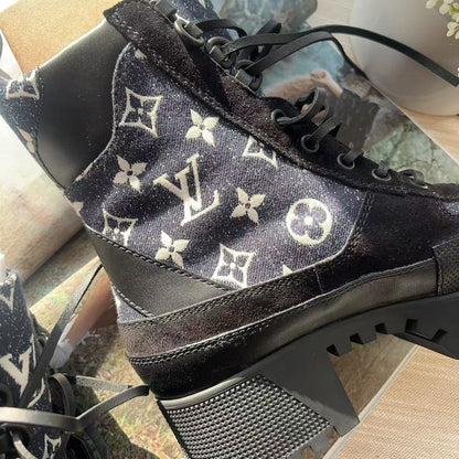 Black high-heeled shoes with white monogram pattern on a reflective surface