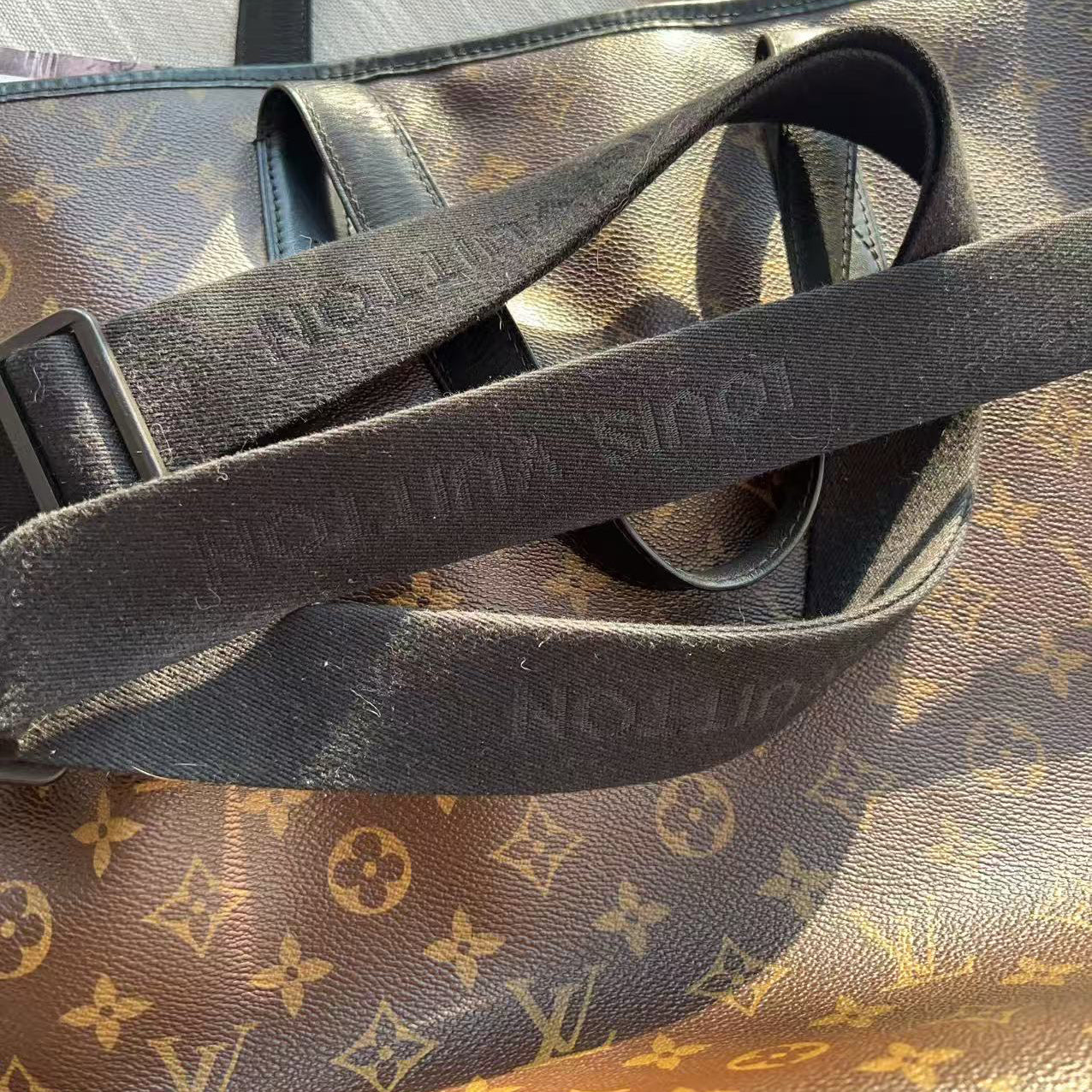 Black leather strap on a Louis Vuitton monogram handbag