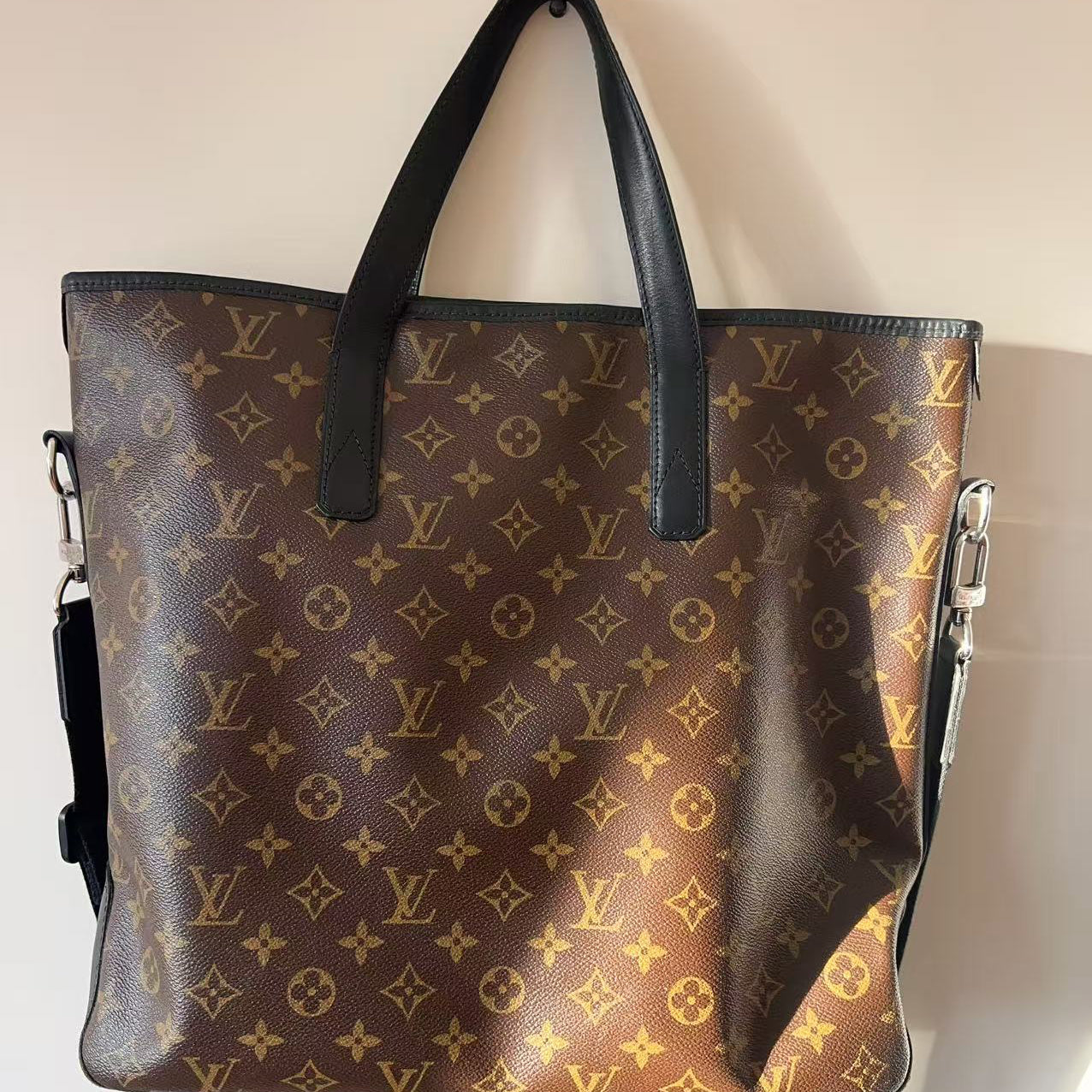 Designer handbag with monogram pattern on a neutral background