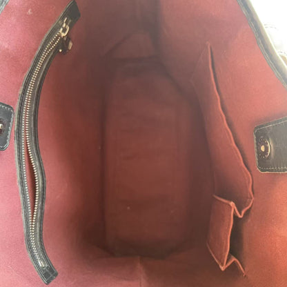 Close-up of a red handbag with a gold zipper on a white background