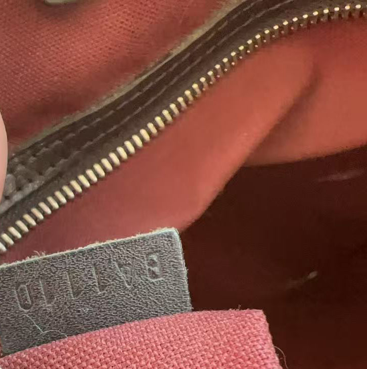 Close-up of a label on a red fabric item with a zipper.