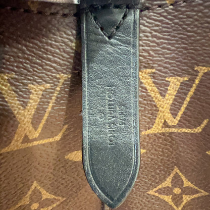 Close-up of a Louis Vuitton monogram bag with a leather tag.