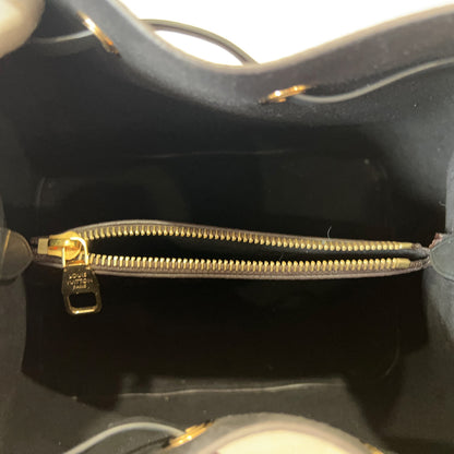 Close-up of a black handbag with a gold zipper.