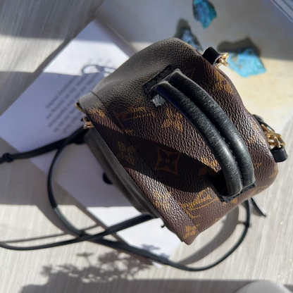 Louis Vuitton monogram handbag on a textured surface with a blurred background