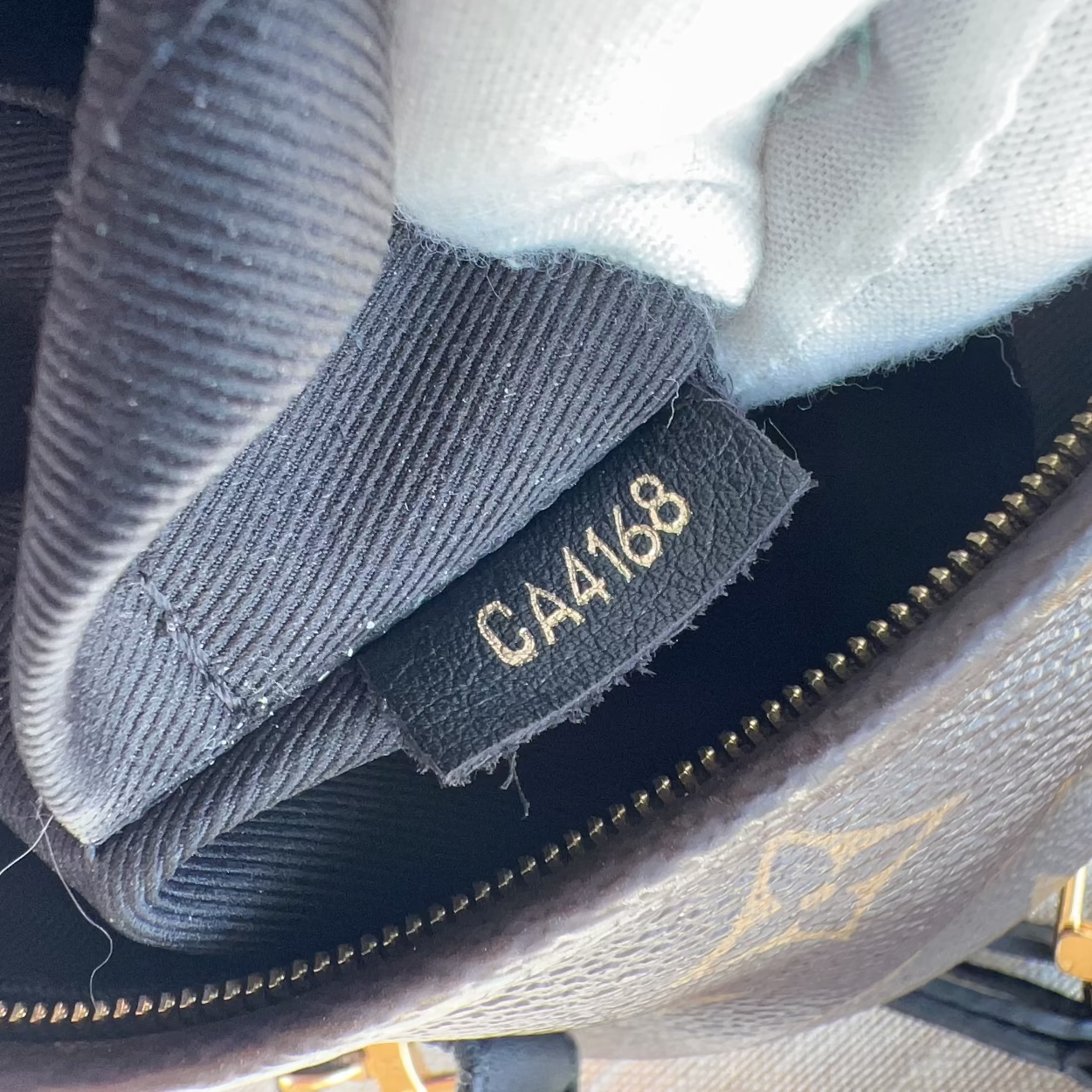 Close-up of a textured fabric with a gold tag displaying 'CA4168' on a dark background.