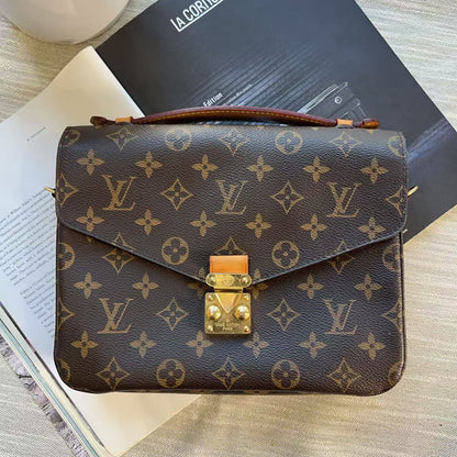 A Louis Vuitton monogram shoulder bag in brown coated canvas with gold-tone hardware, laid flat on top of books and a magazine on a light wood surface.