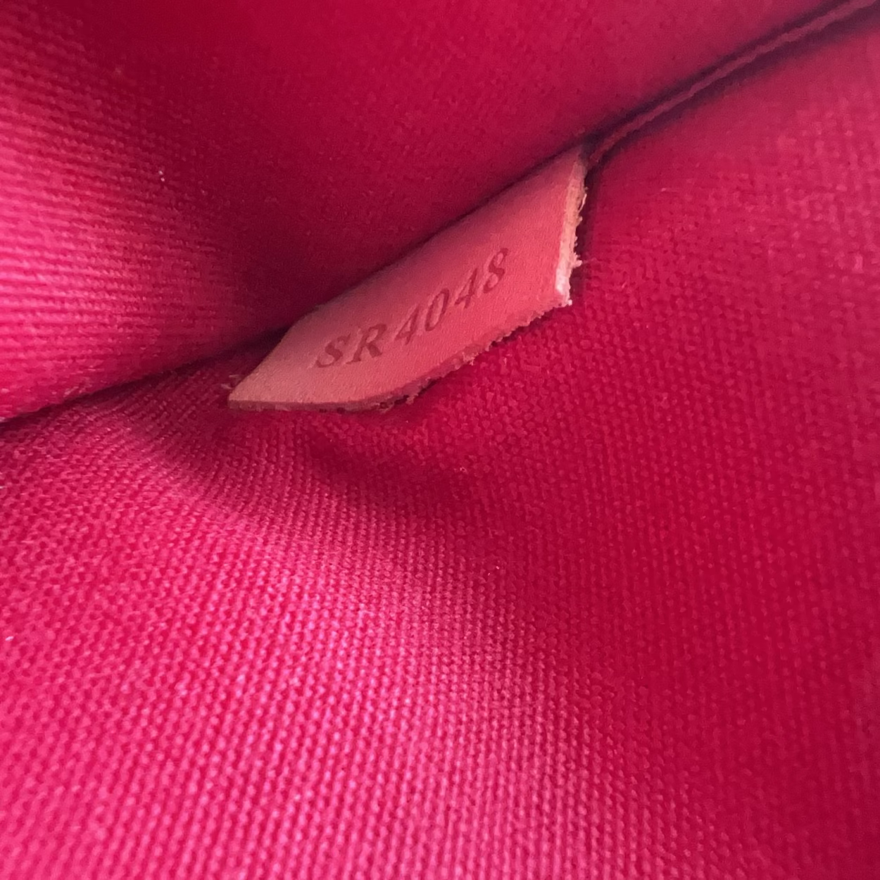 Close-up of a pink fabric with a visible brand label.