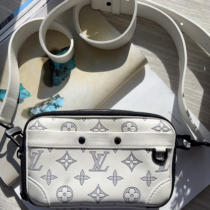 Designer handbag with monogram pattern on a wooden surface
