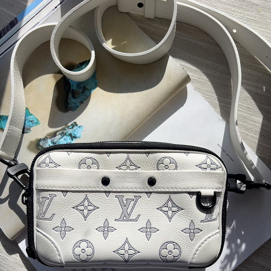 Designer handbag with monogram pattern on a wooden surface
