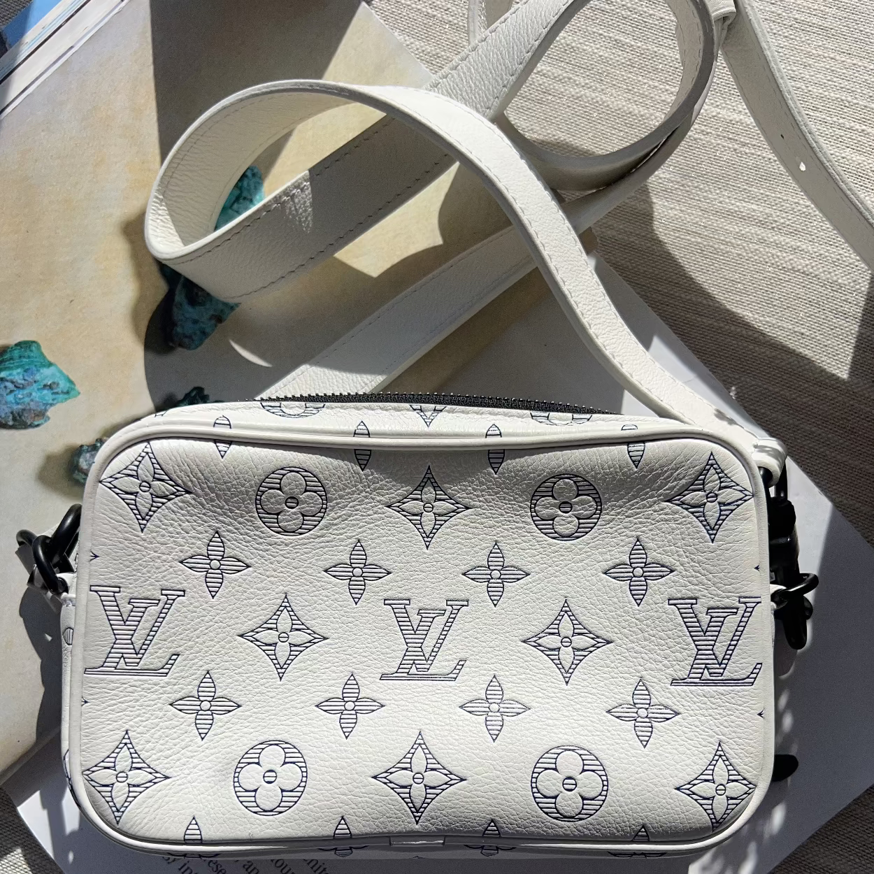 Louis Vuitton monogram patterned bag on a textured surface