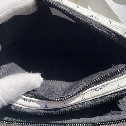 Close-up of a zipped bag with a white interior and gray exterior, showing signs of wear.