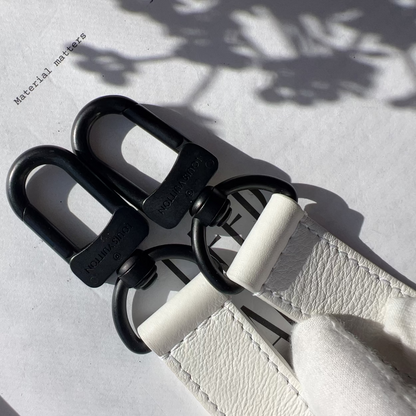 Black and white belt buckle on a textured surface with 'Material Matters' text.