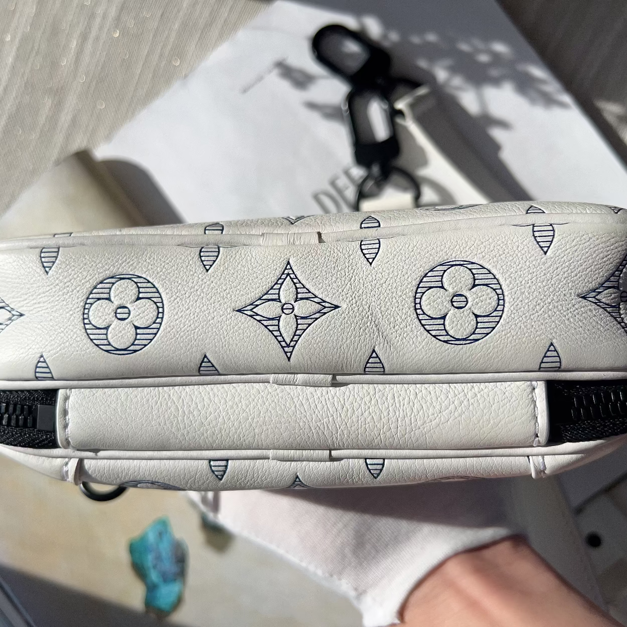 Patterned pouch with black zipper on a light surface