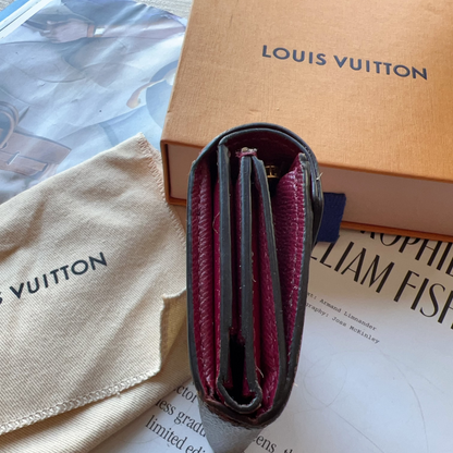Louis Vuitton wallet and pouch on a magazine with visible branding