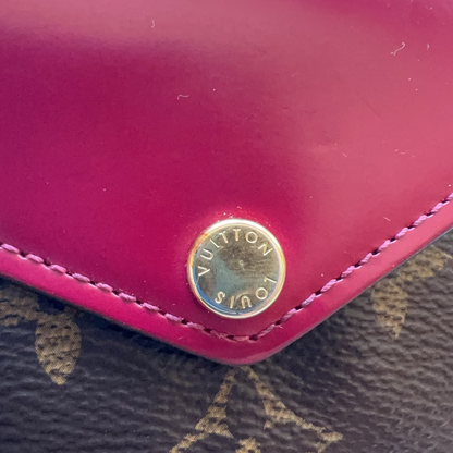 Close-up of a pink Louis Vuitton wallet with gold logo.