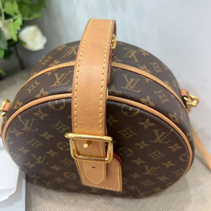 Round handbag with monogram pattern on a neutral background