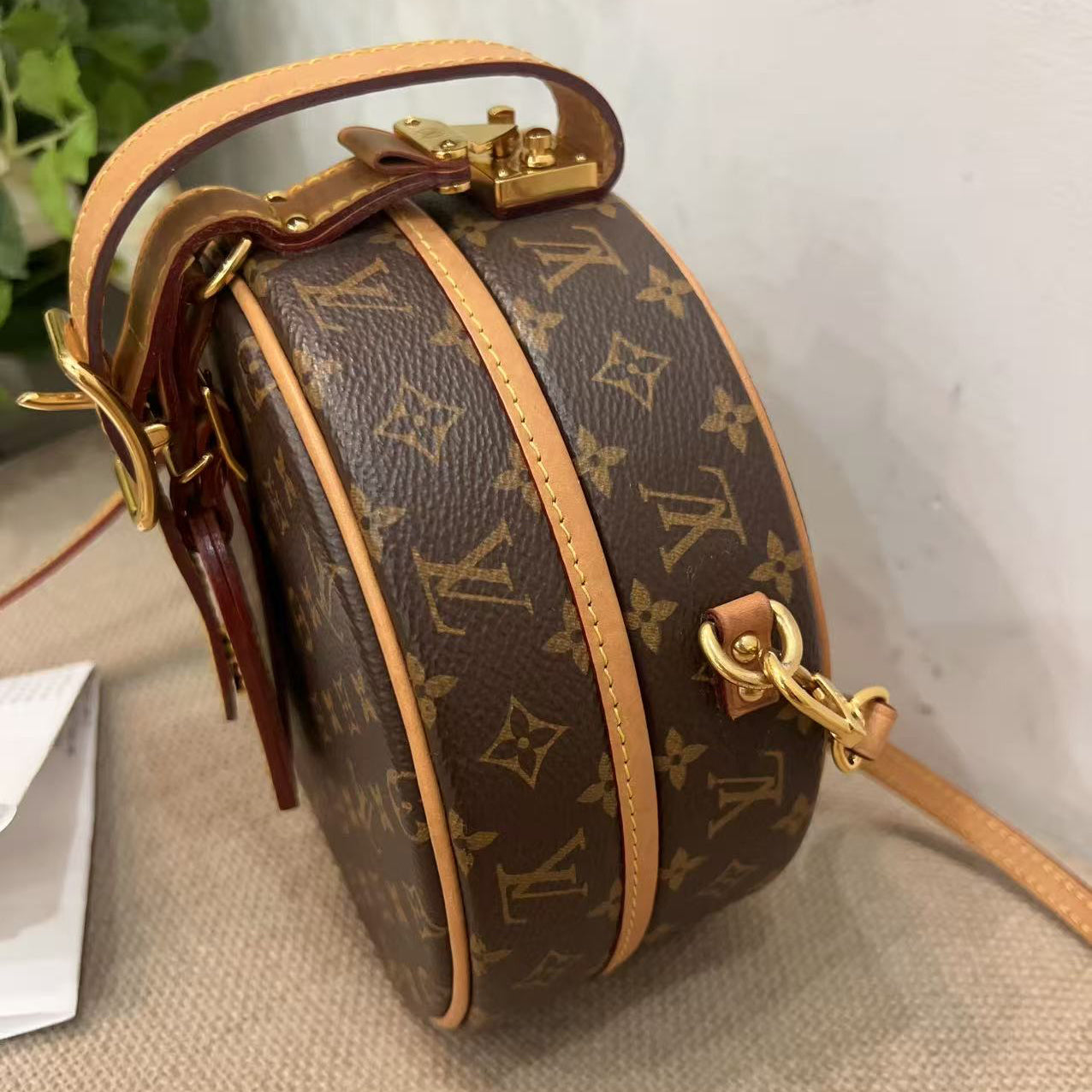 Louis Vuitton handbag with monogram pattern on a neutral background