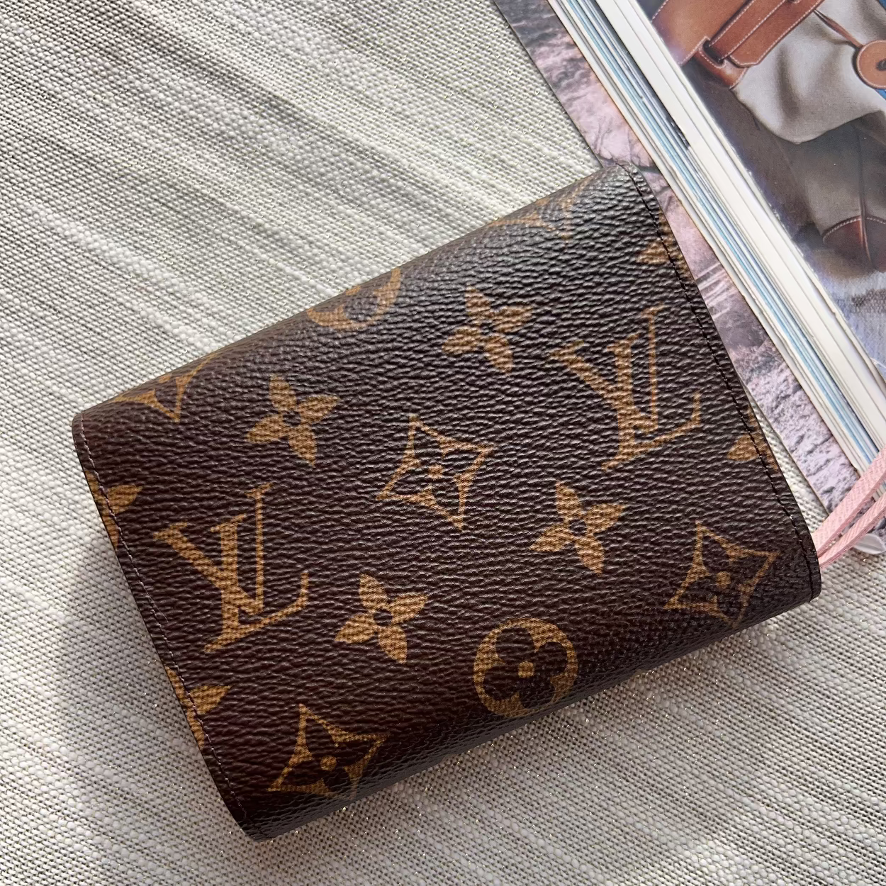 Louis Vuitton wallet with monogram pattern on a textured surface