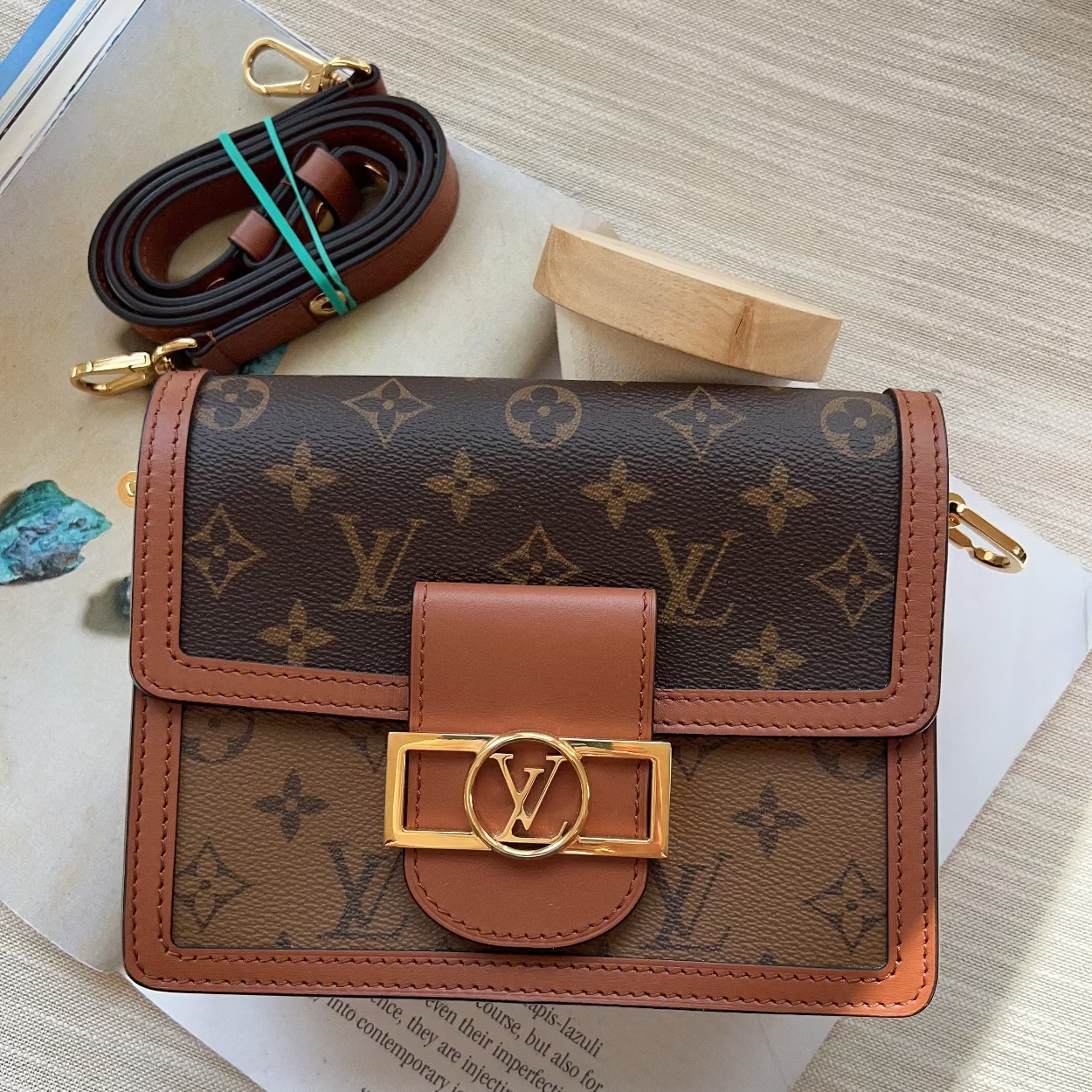 Designer wallet with monogram pattern on a light wooden surface