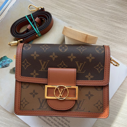 Designer wallet with monogram pattern on a light wooden surface