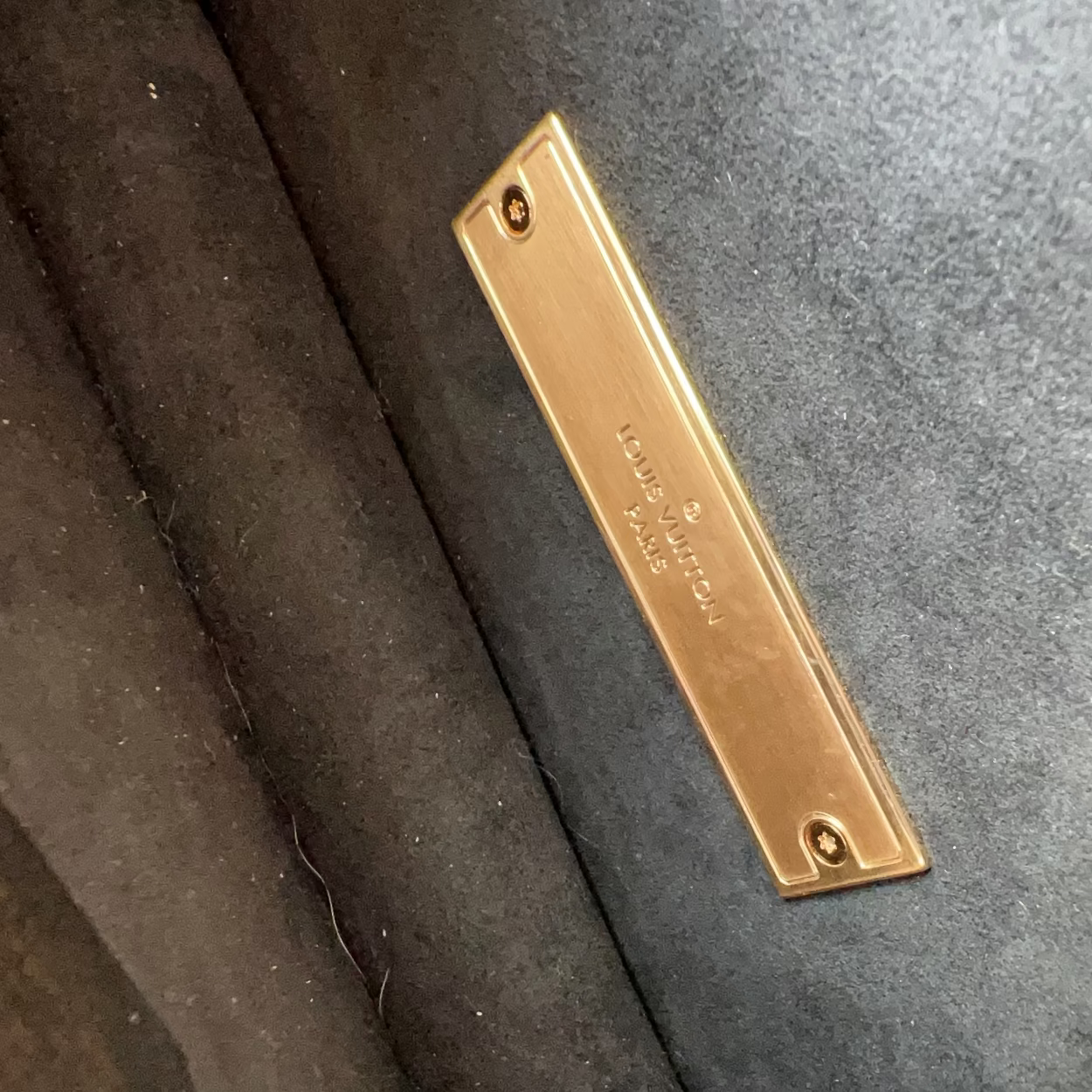 Gold rectangular object with text on a dark textured surface