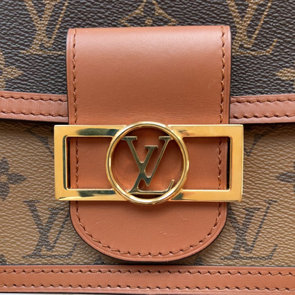 Close-up of a brown leather strap with gold buckle on a patterned surface