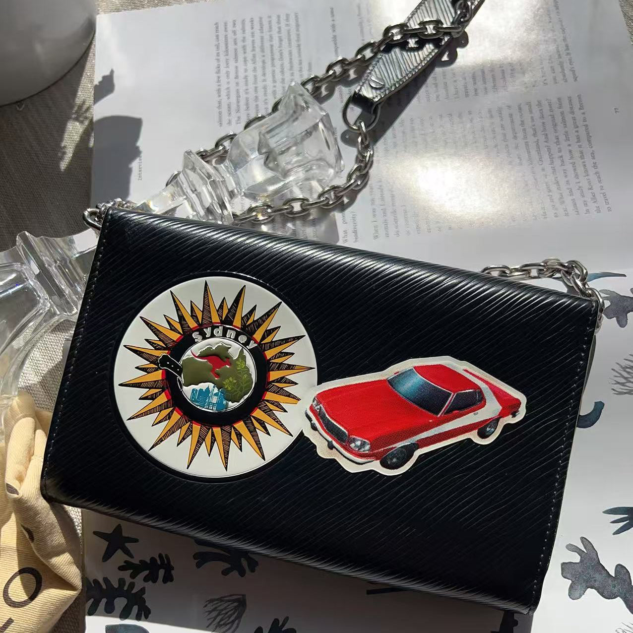 Black handbag with car and sun design