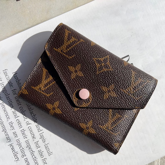 Brown wallet with monogram pattern on a textured surface