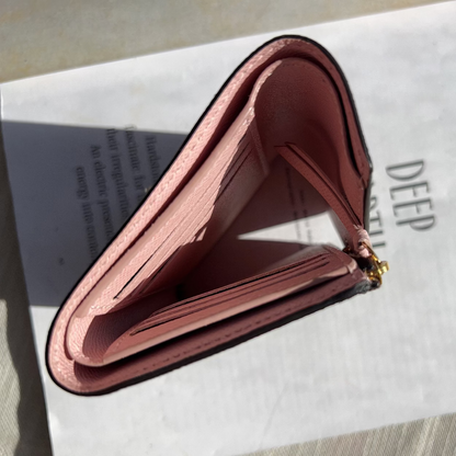 Pink wallet on a white surface with text partially visible