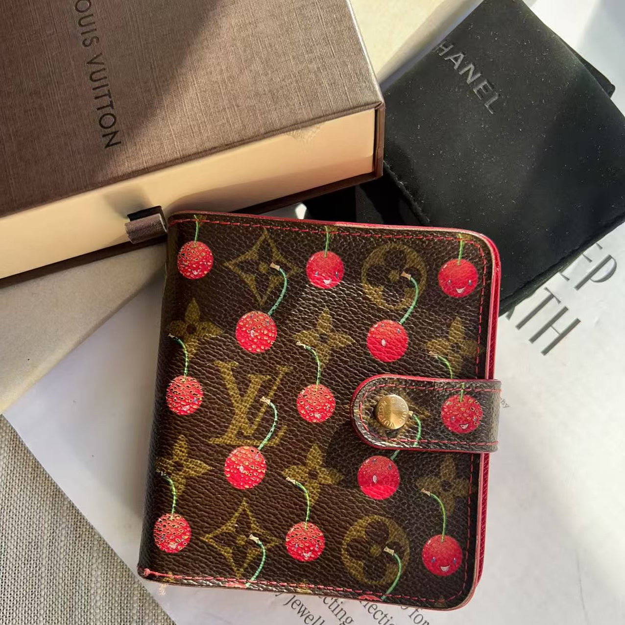 Louis Vuitton wallet with cherry design on a magazine