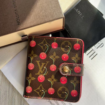 Louis Vuitton wallet with cherry design on a magazine