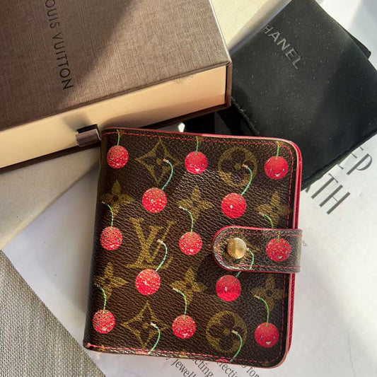 Louis Vuitton wallet with cherry design on a magazine