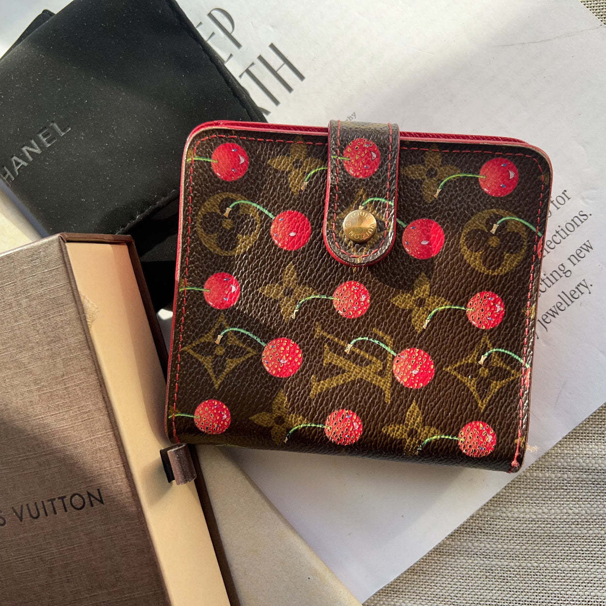 Louis Vuitton wallet with cherry design on a magazine