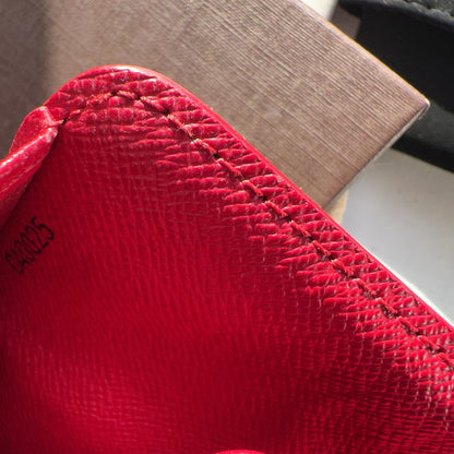 Close-up of a red textured fabric with visible stitching details.