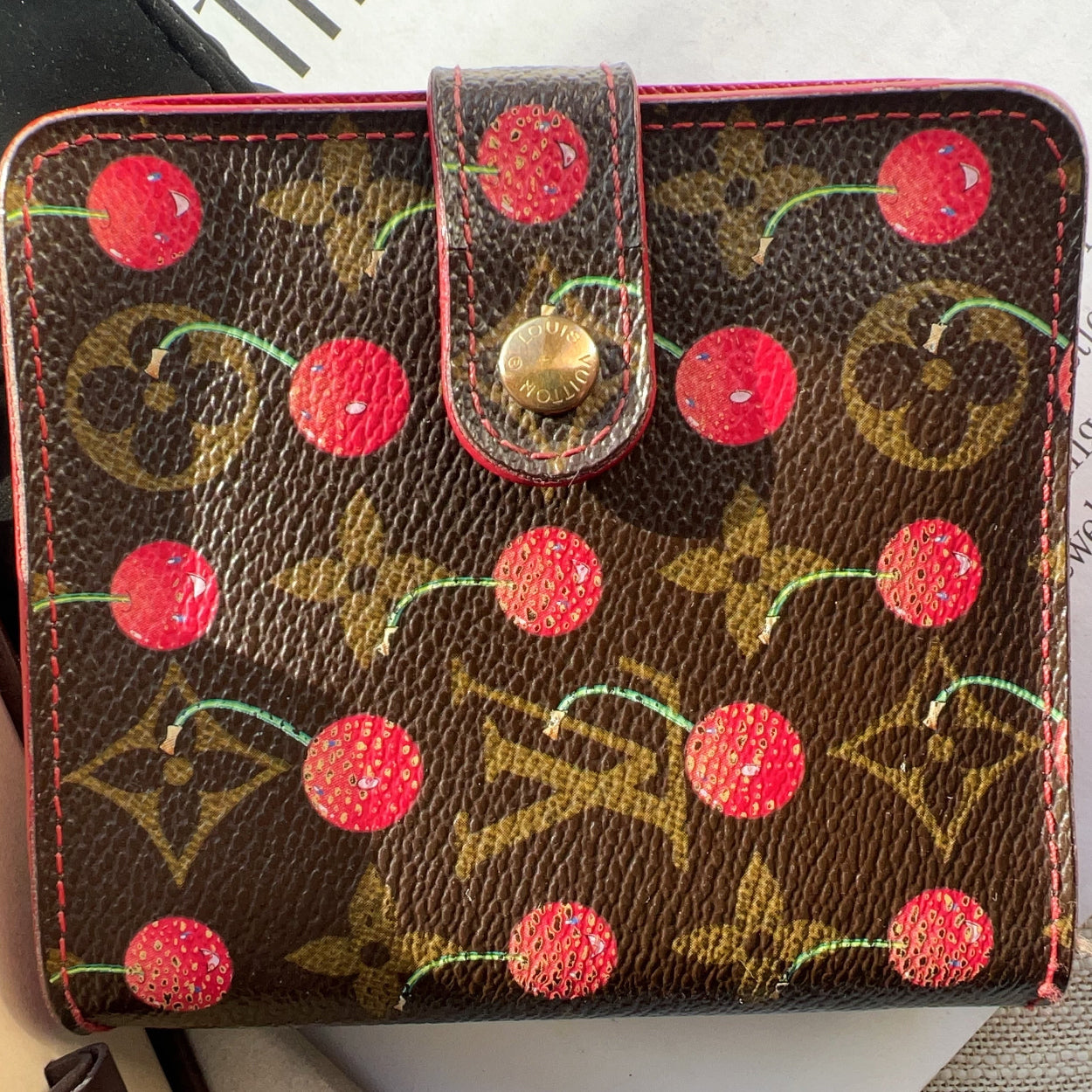 Designer handbag with cherry pattern on a surface