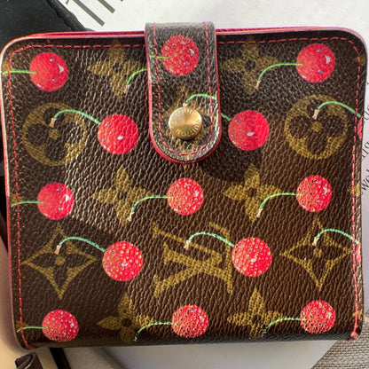 Designer handbag with cherry pattern on a surface