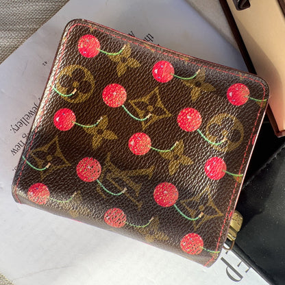 Designer wallet with cherry design on a surface