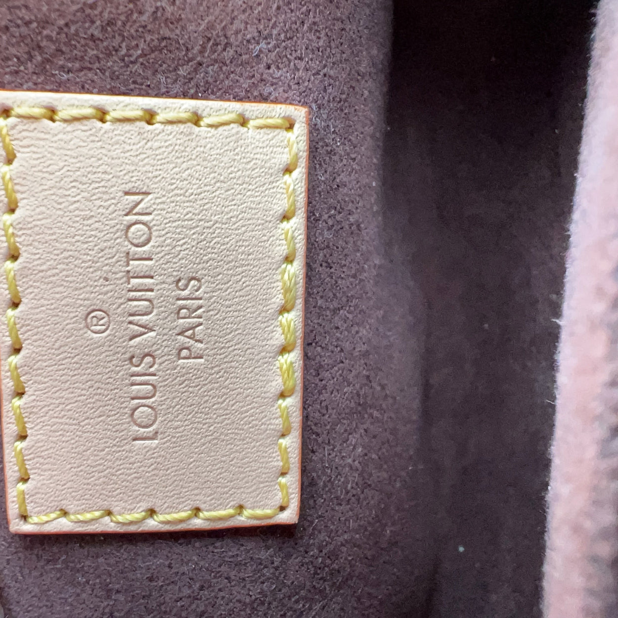 Louis Vuitton label on a brown leather surface
