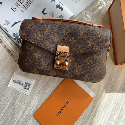 Louis Vuitton monogram handbag with brand card on a textured surface