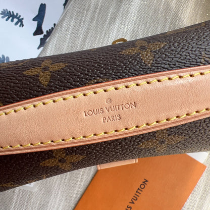 Louis Vuitton wallet with monogram pattern and visible brand logo.